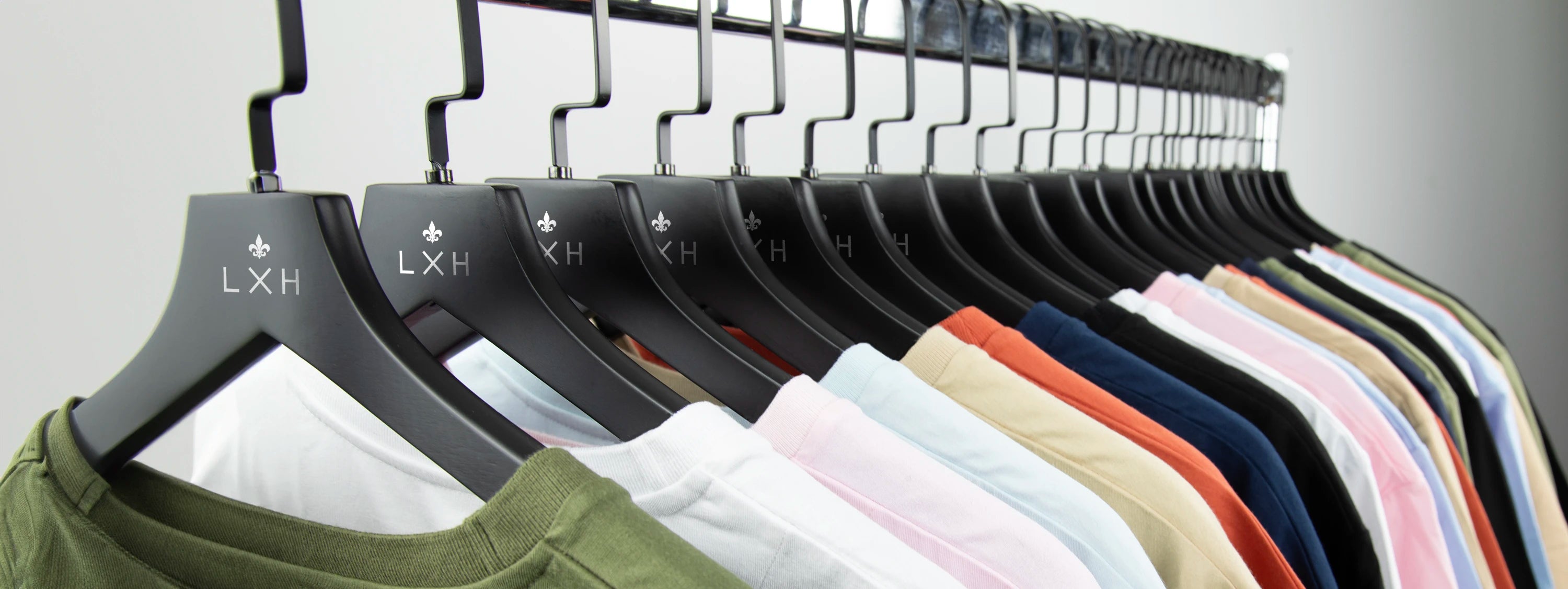 Collection de t-shirts colorés suspendus sur des cintres alignés dans une boutique