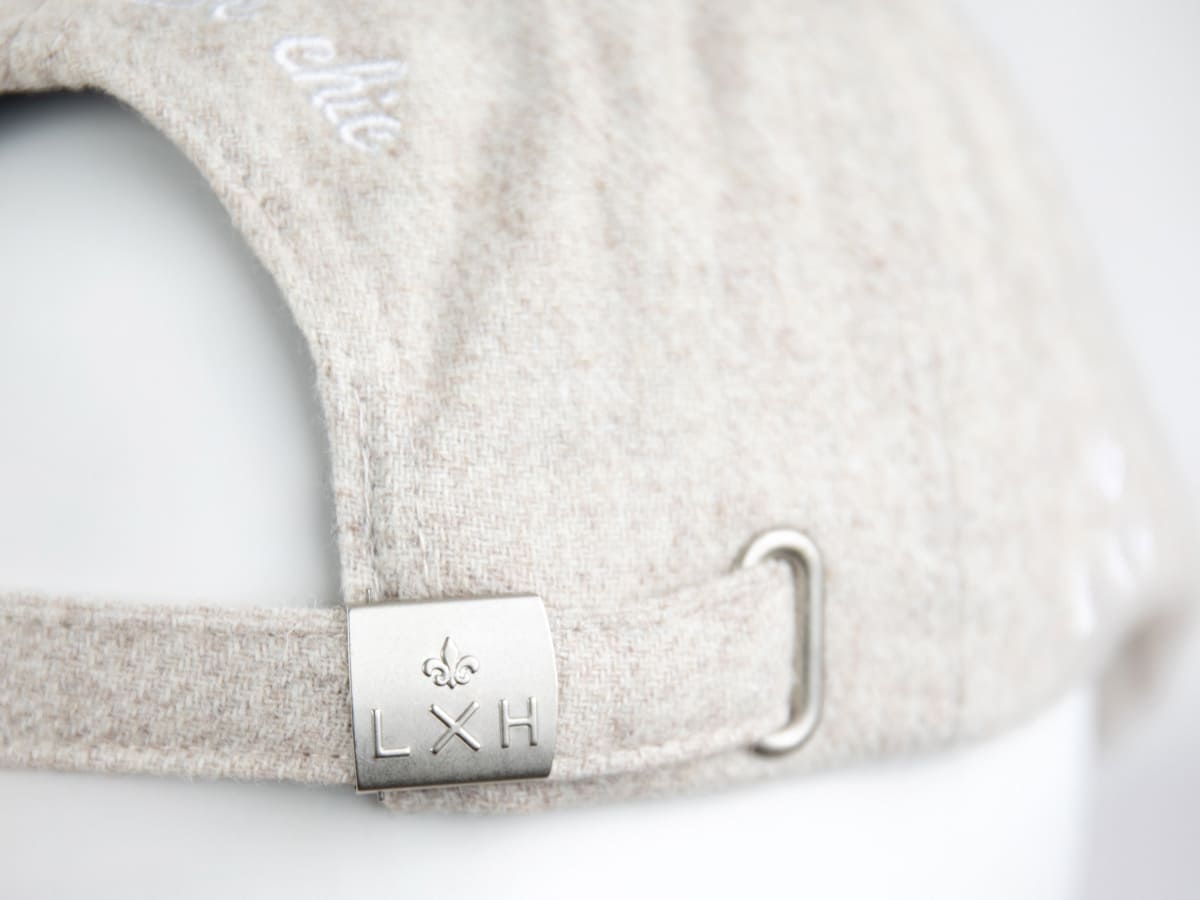 Détail arrière du béret feutrine blanc cassé LXH, boucle métal brossé fleur de lys et lettres LXH avec bride ajustable