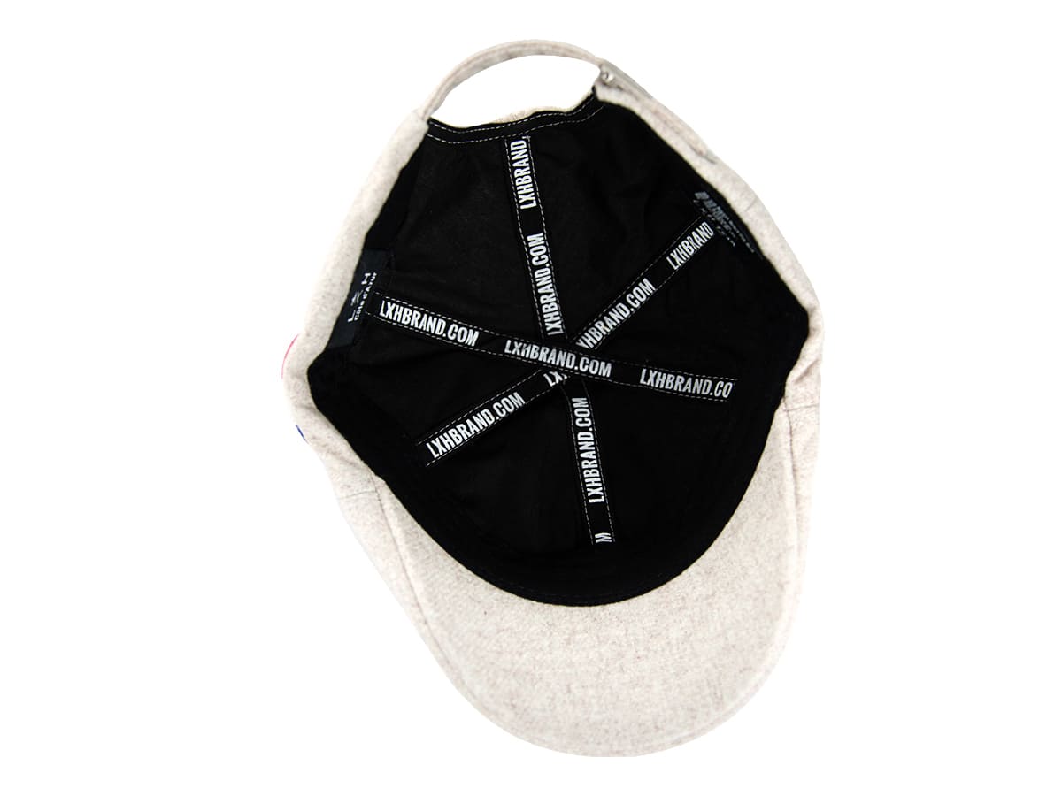 Intérieur béret feutrine blanc cassé LXH, doublure noire avec rubans de renfort siglés LXHBRAND.COM en croix sur calotte.