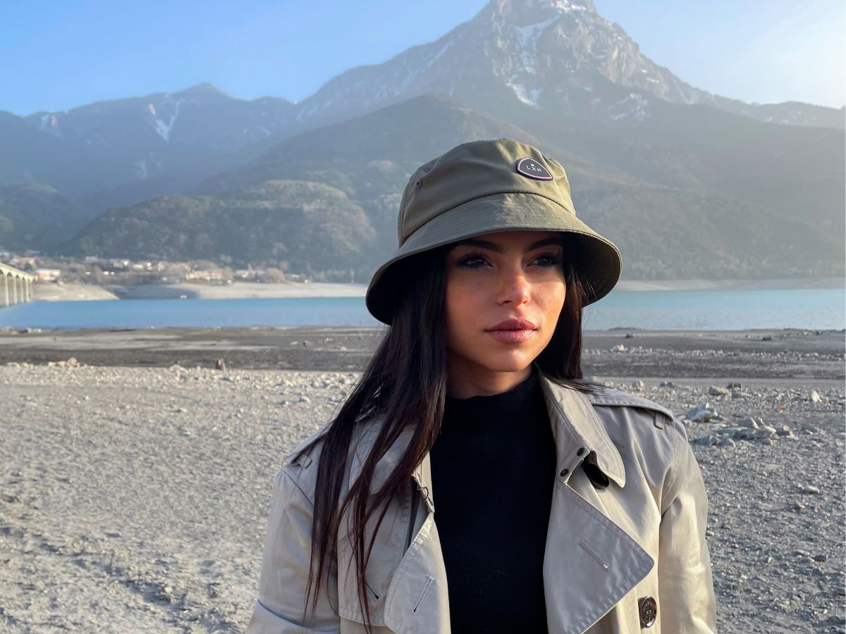 Femme portant un Bob Nylon Kaki, posé en extérieur avec paysage de montagne en arrière-plan