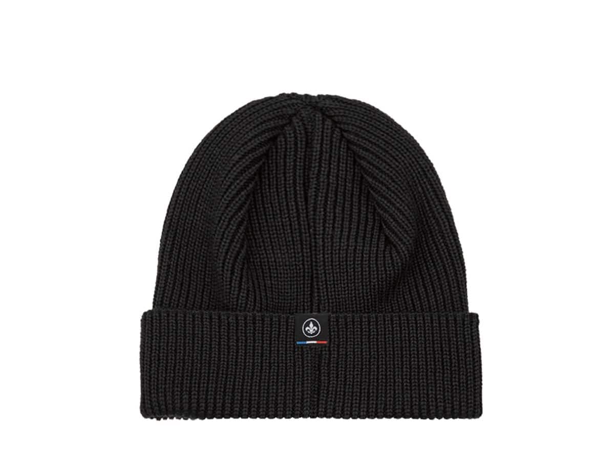 Bonnet laine mérinos noir LXH vu trois-quarts, étiquette discrète tricolore avec fleur de lys cousue sur le revers.