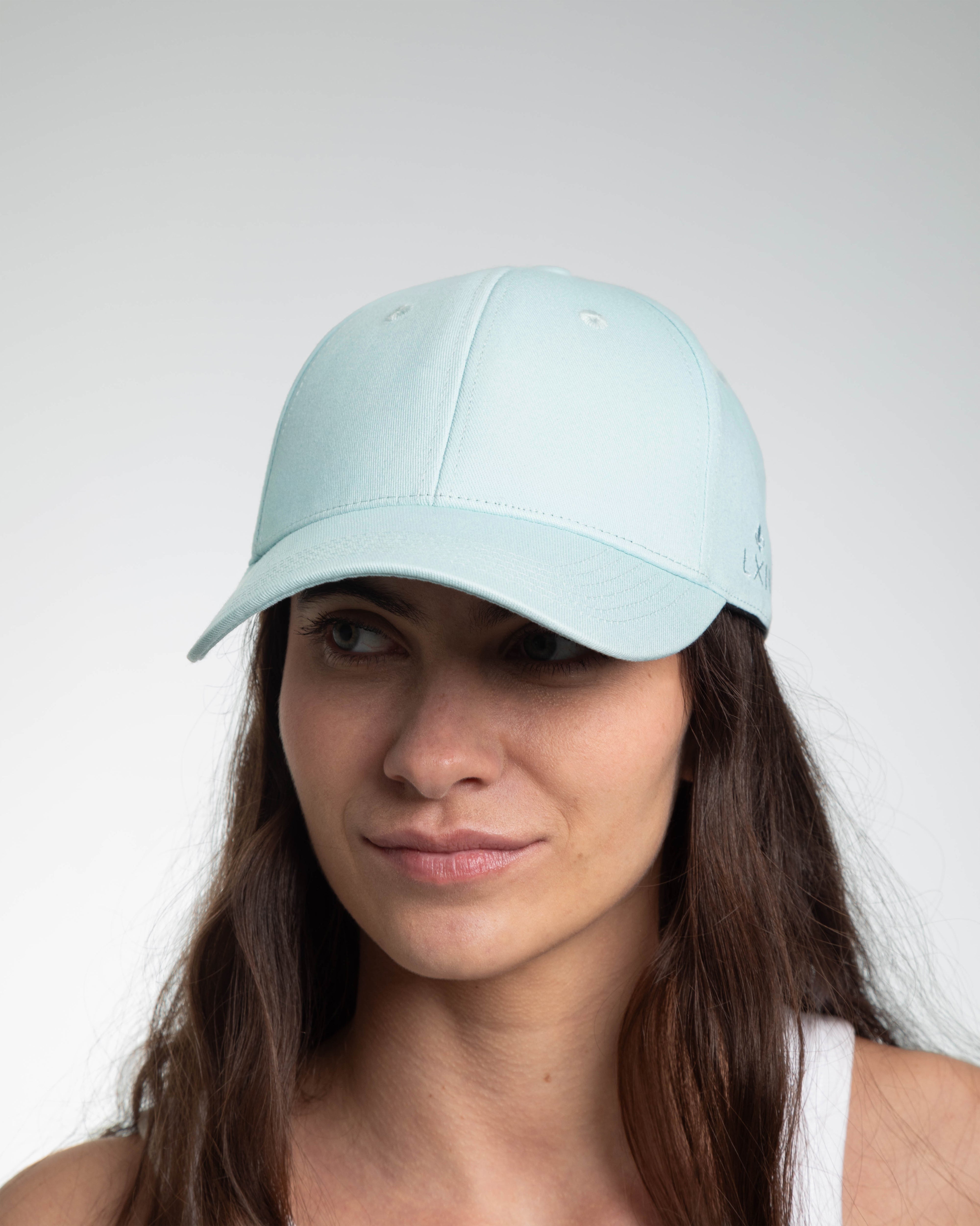 Casquette bleu ciel coton de la marque LXH portée par une femme au look décontracté