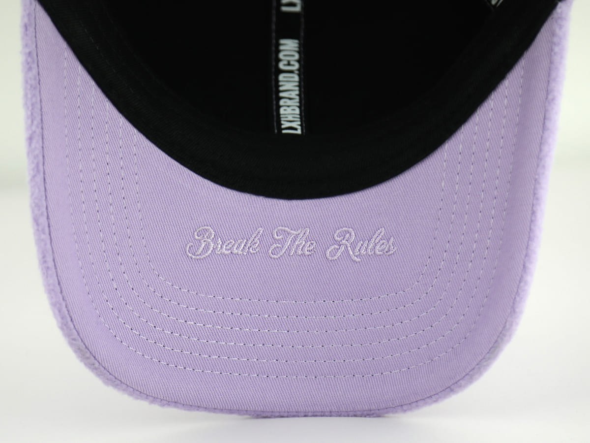Casquette polaire lavande avec inscription 'Break The Rules' sur la visière intérieure