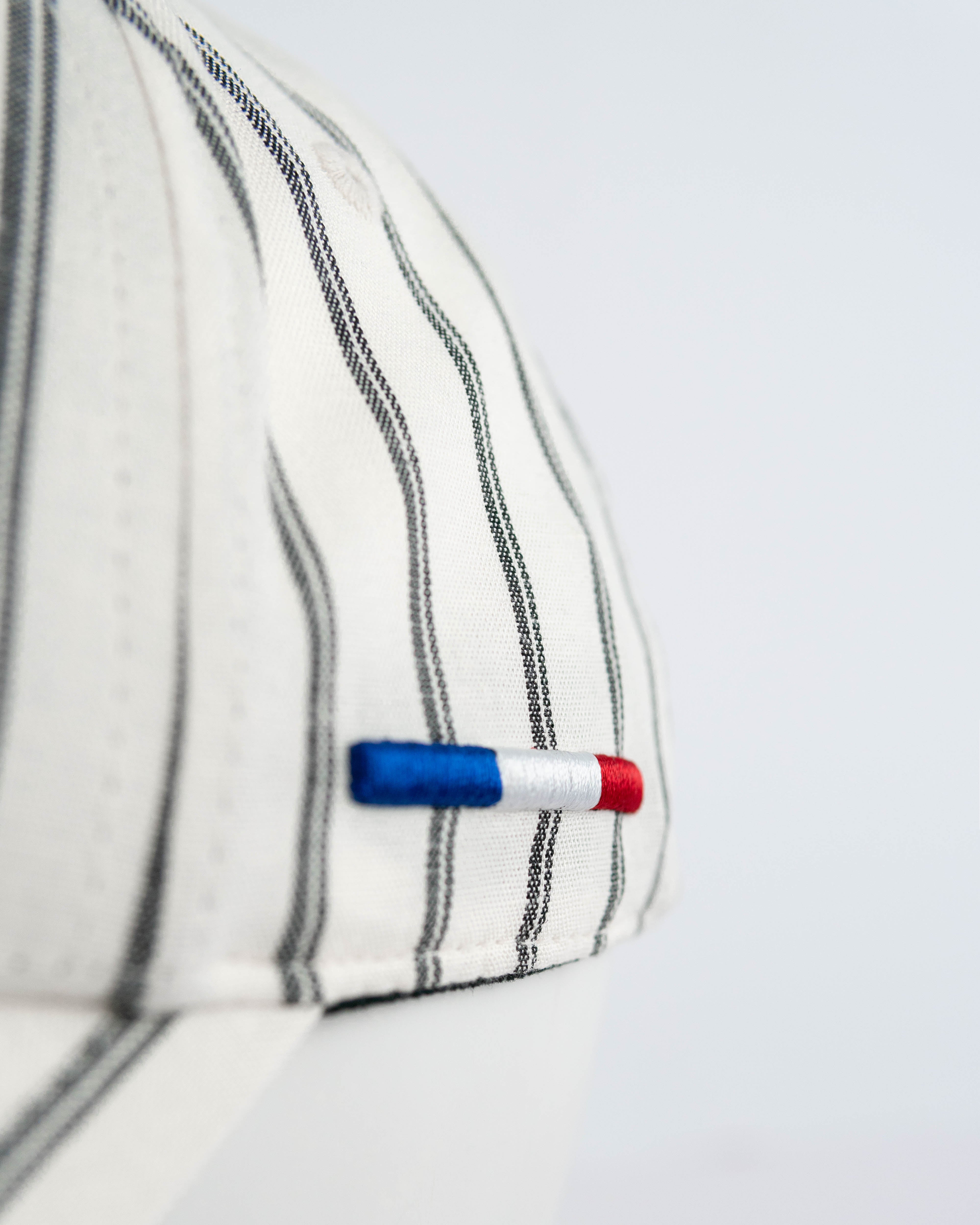 Casquette rayée beige homme avec détail tricolore sur le côté pour un style élégant