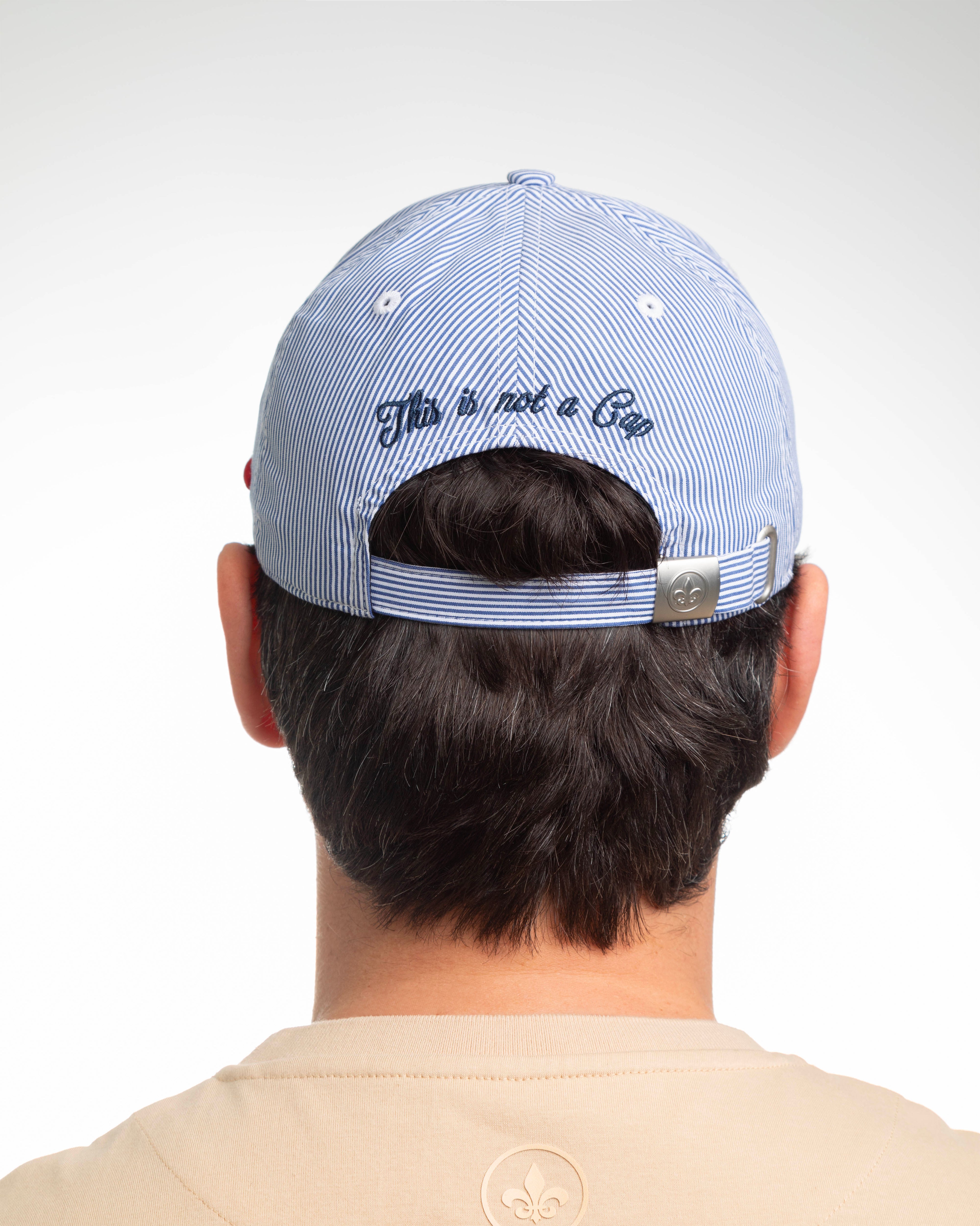 Vue arrière d'une casquette rayures blanc / bleu marine LXH avec broderie sur la sangle