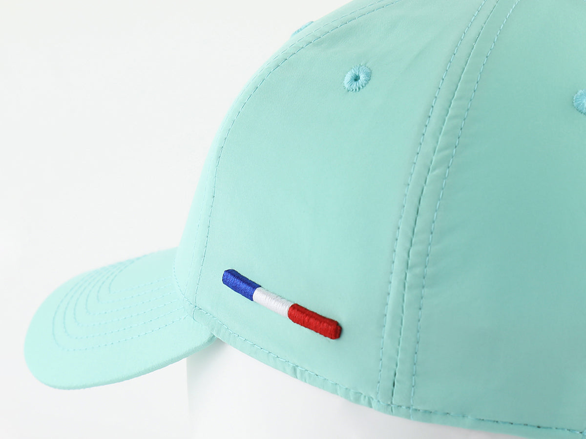 Casquette vert pastel nylon LXH avec une broderie tricolore sur le côté.