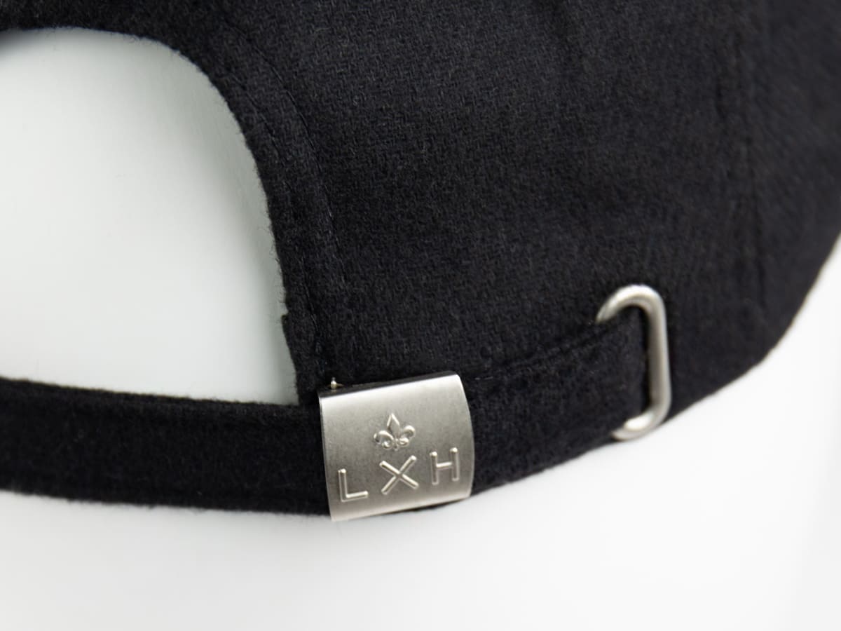 Béret Feutrine Noir LXH gros plan arrière, cursive « This is not a Cap » et fente d'ajustement de la sangle réglable.