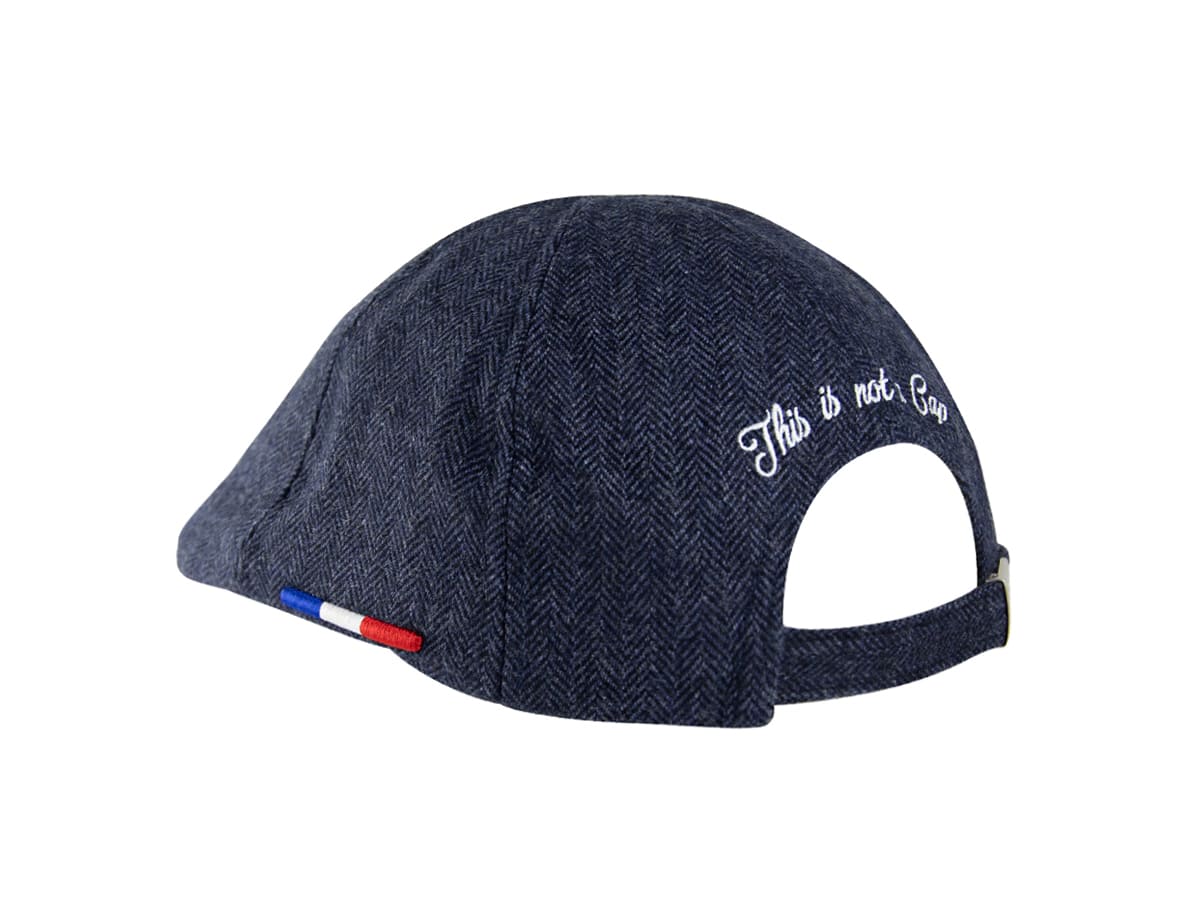 Vue trois-quart arrière du béret plat LXH chevron bleu marine, broderie blanche This is not a Cap et sangle ajustable au dos.