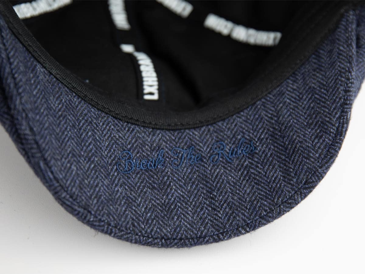 Sous-visière du béret chevron bleu marine LXH avec broderie discrète Break The Rules en fil bleu, signature cachée du modèle.