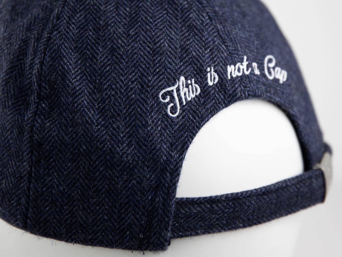 Gros plan du dos du béret LXH chevron bleu marine avec broderie cursive This is not a Cap et sangle d'ajustement.