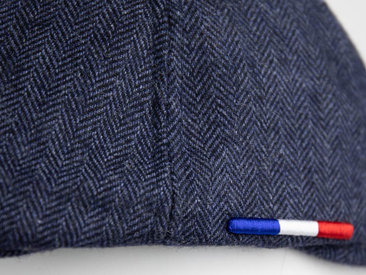 Détail texture tissu chevron bleu marine béret LXH, petite étiquette tricolore bleu blanc rouge cousue sur la couture