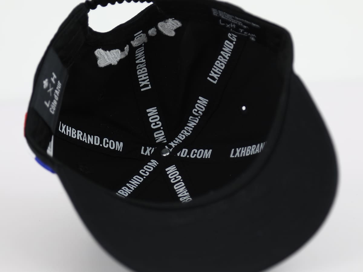 Intérieur de casquette bébé noire LXH avec logo LXHBRAND.COM visible sur les coutures
