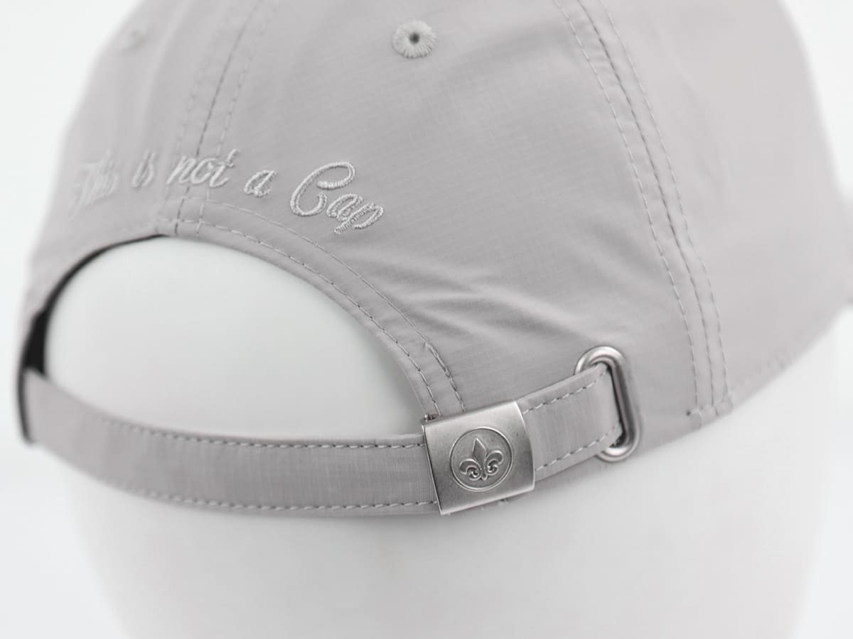 Macro arrière LXH nylon gris clair, broderie cursive blanche This is not a Cap, boucle argentée fleur de lys