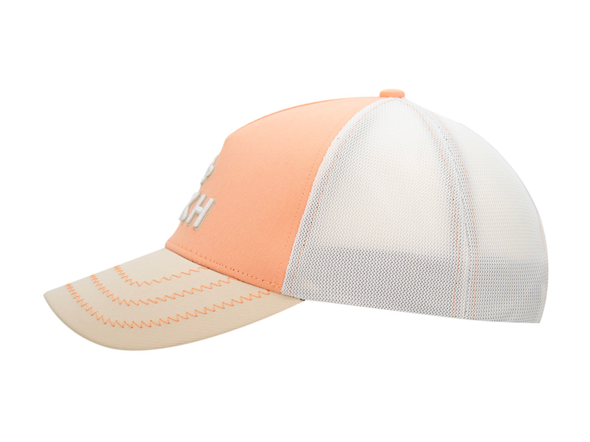 Profil gauche de la casquette Évasion abricot, panneaux arrière en mesh blanc et visière surpiquée.