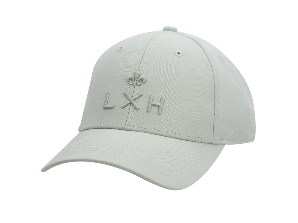 Casquette Héritage LXH coton vert sauge sans ligne, trois quarts avant, monogramme et fleur de lys ton sur ton.