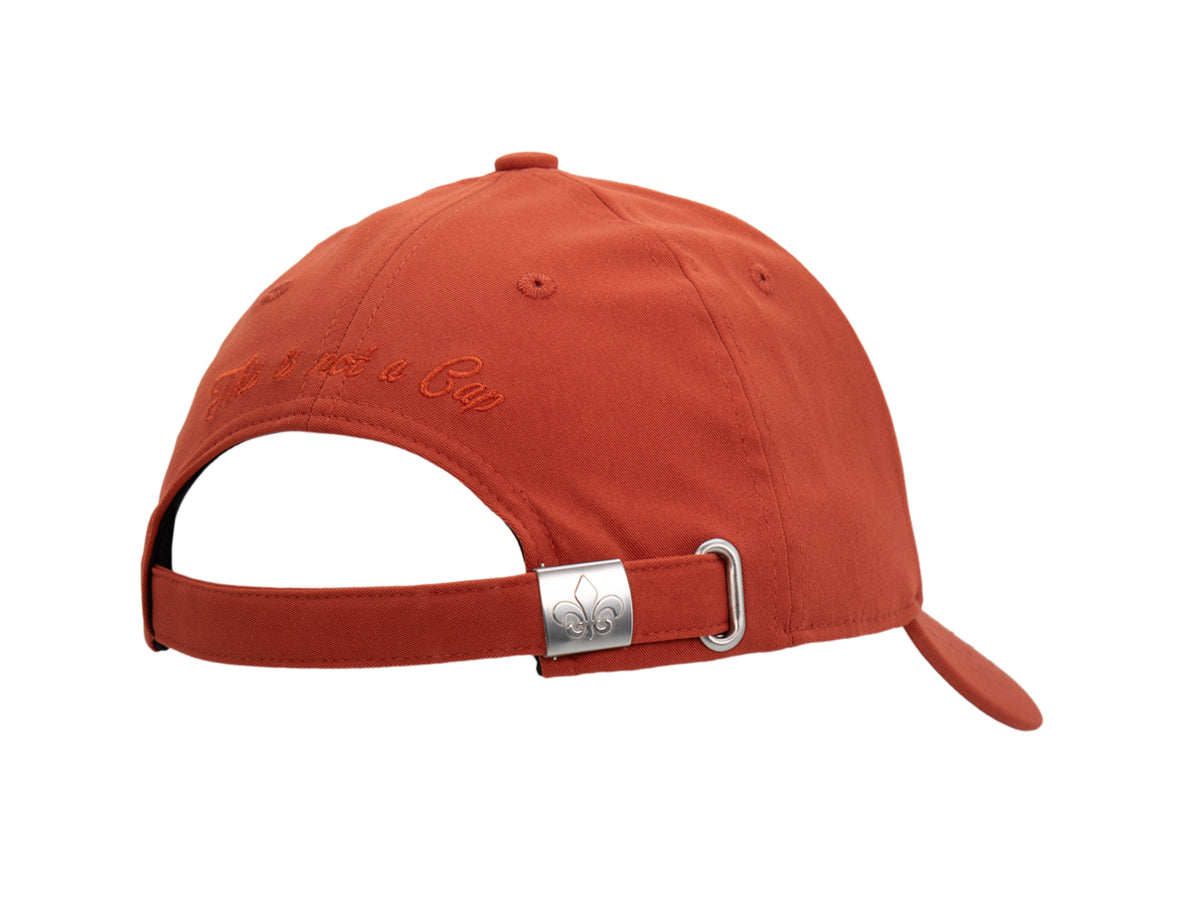 Arrière de la casquette Héritage terracotta, ouverture de réglage et boucle métal gravée fleur de lys.
