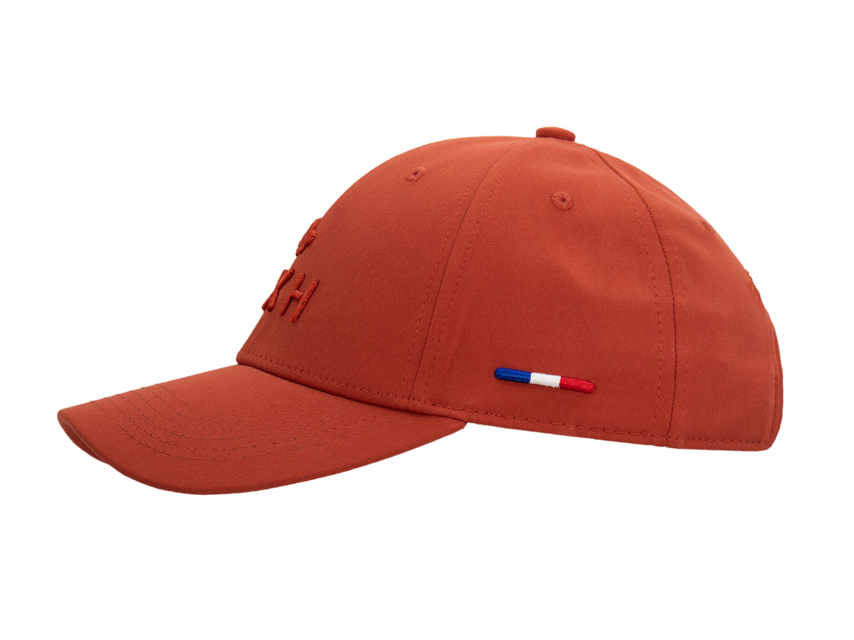 Profil gauche de la casquette Héritage terracotta, drapeau français brodé à la base du panneau, visière incurvée.