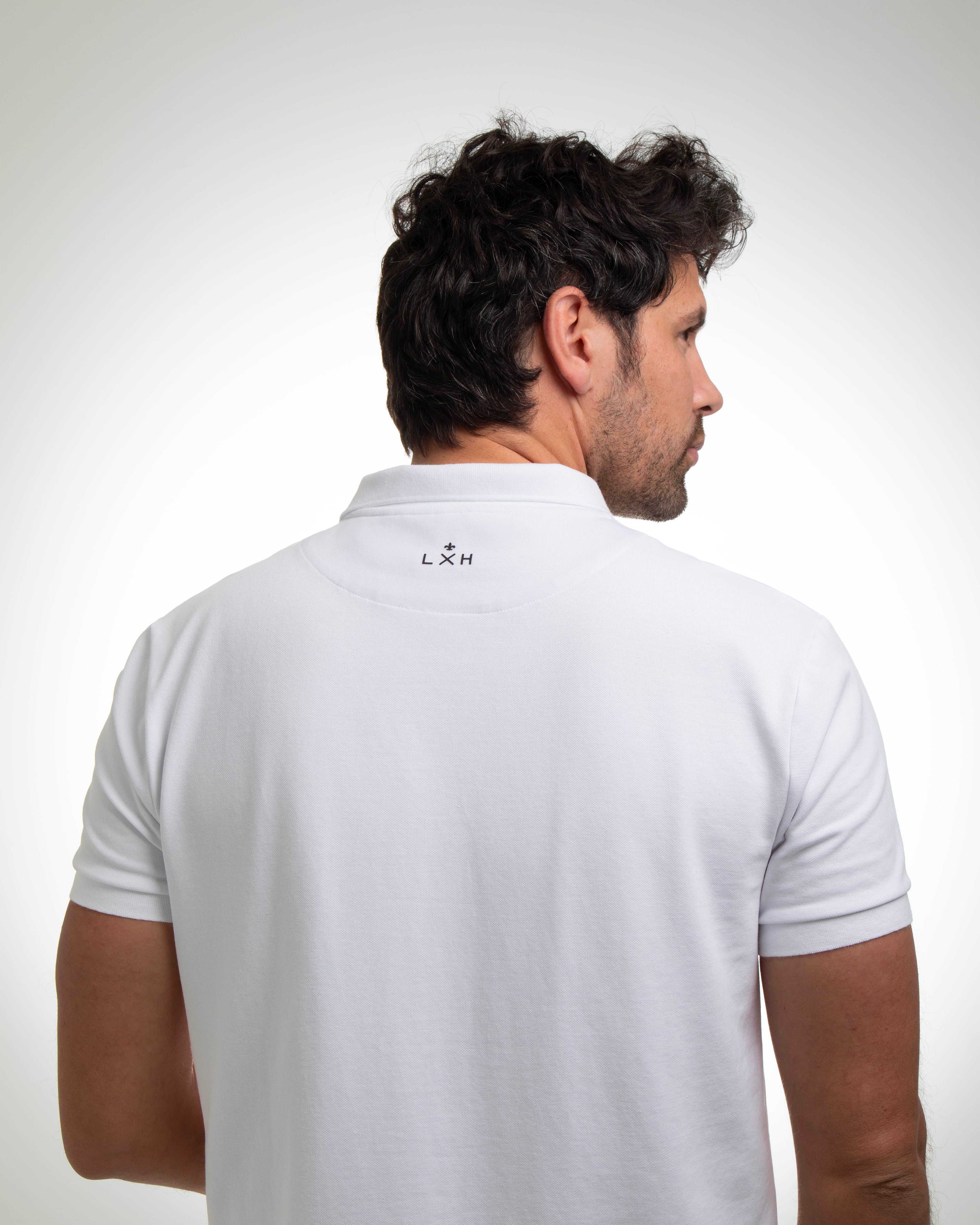 Homme portant un polo coton blanc de la marque LXH vu de dos avec logo au col