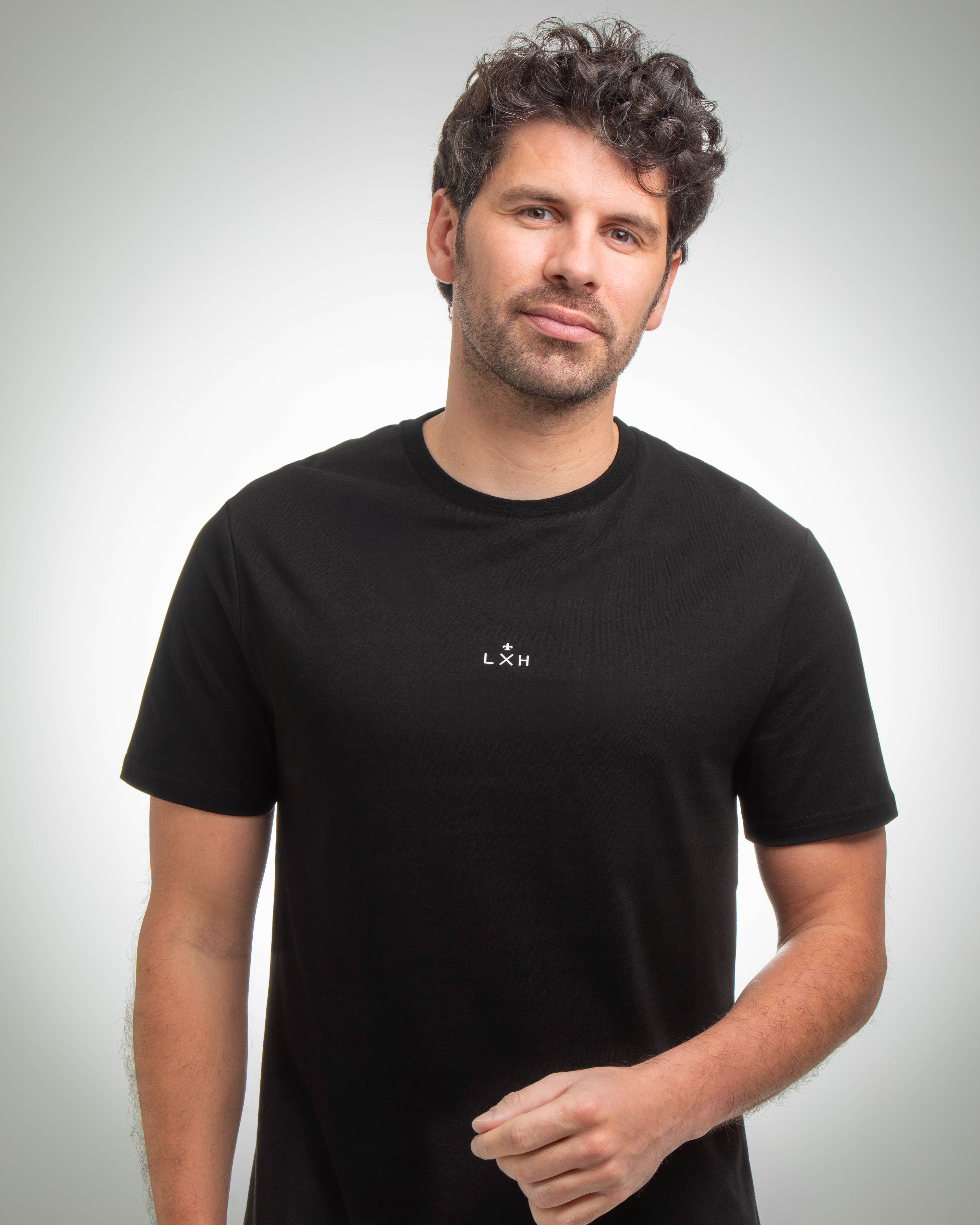 Homme portant un T-shirt Coton noir LXH à manches courtes avec logo minimaliste sur la poitrine