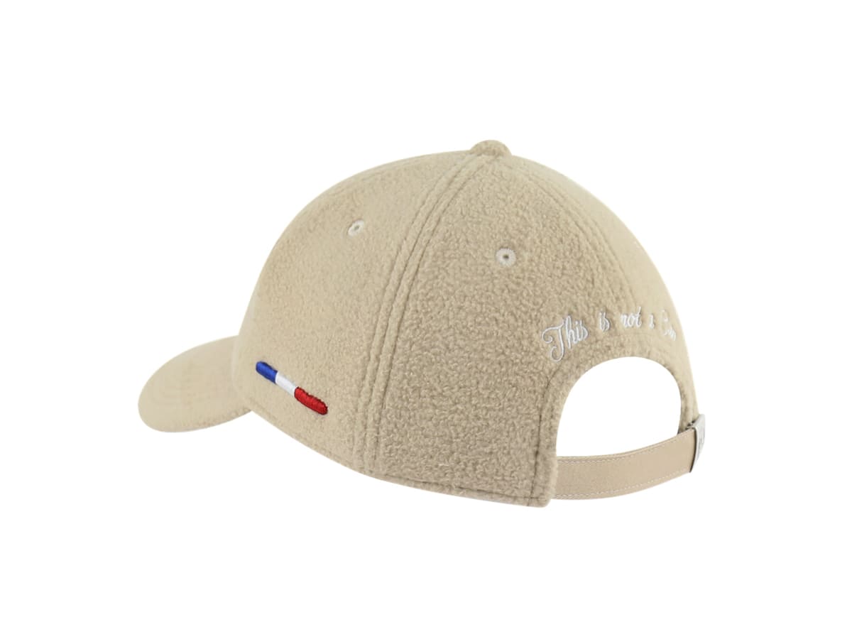 Casquette LXH Héritage polaire beige trois quarts arrière, broderie cursive blanche This is not a Cap au-dessus de la sangle.
