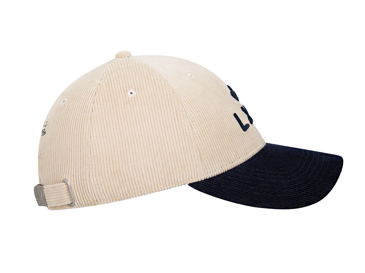 Profil droit casquette LXH Héritage, calotte beige velours côtelé, visière bleu marine, boucle métal fleur de lys nuque.