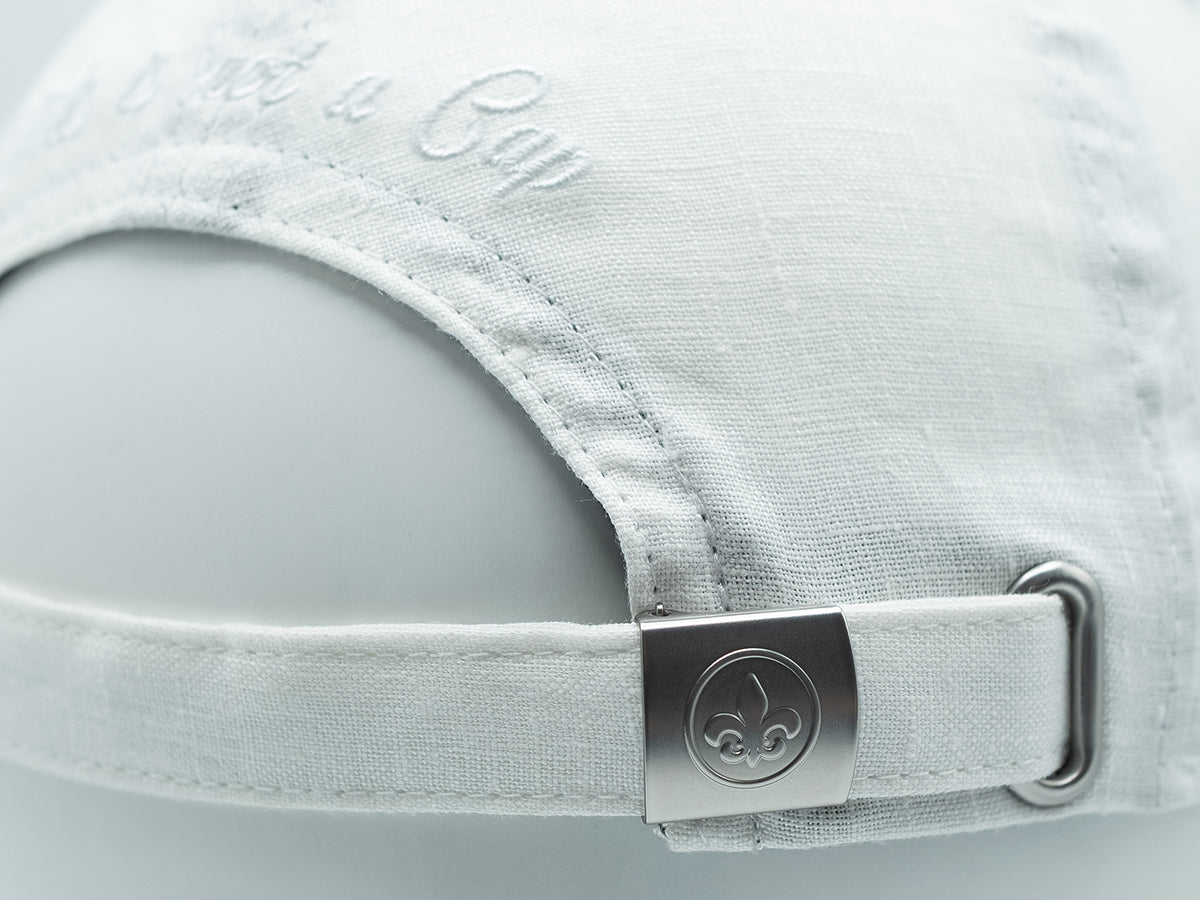 Détail d'une casquette lin blanc ton sur ton avec ajustement en métal pour un style élégant