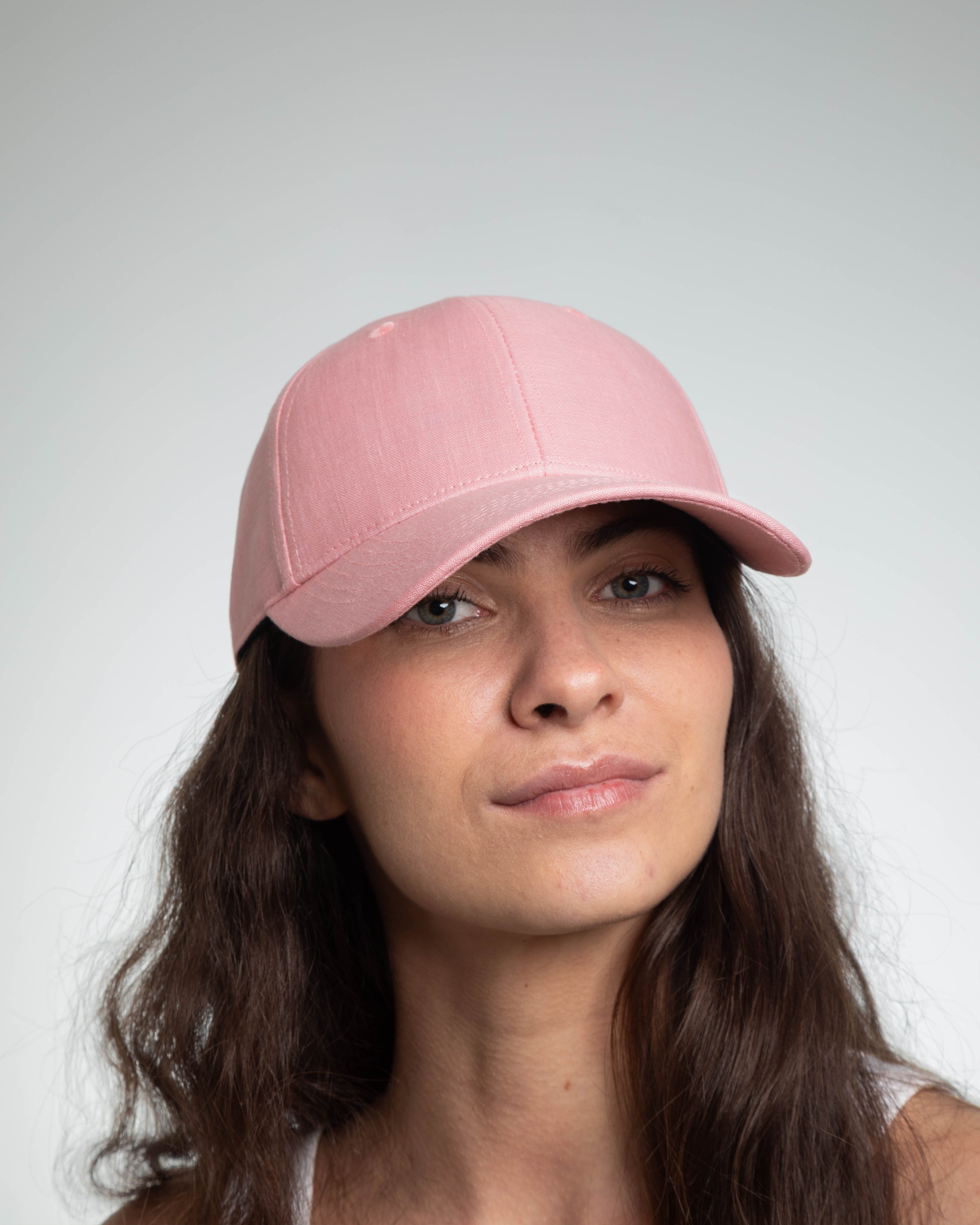 Casquette lin rose femme de LXH portée par une femme avec de longs cheveux bouclés