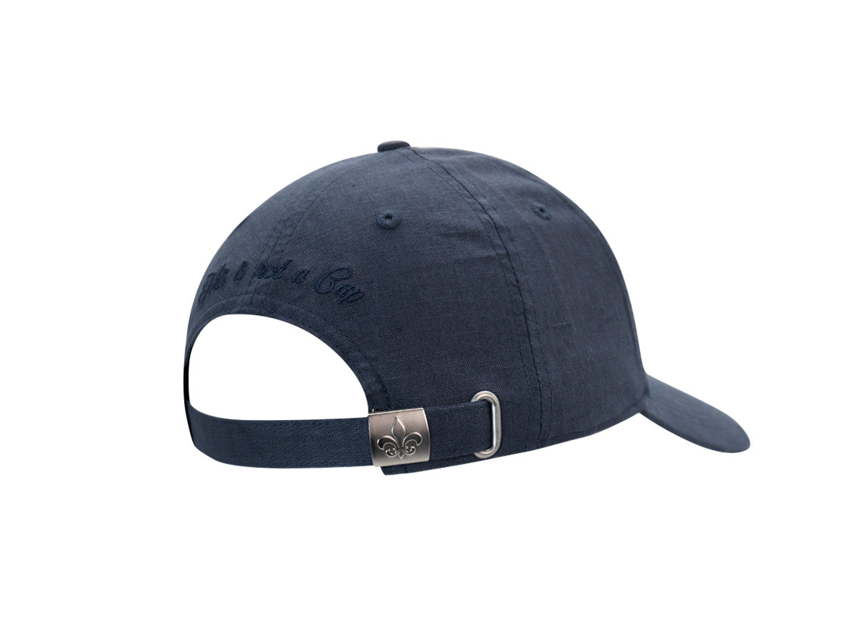 Arrière de la casquette Héritage en lin bleu marine, ouverture de réglage et boucle métal gravée fleur de lys.
