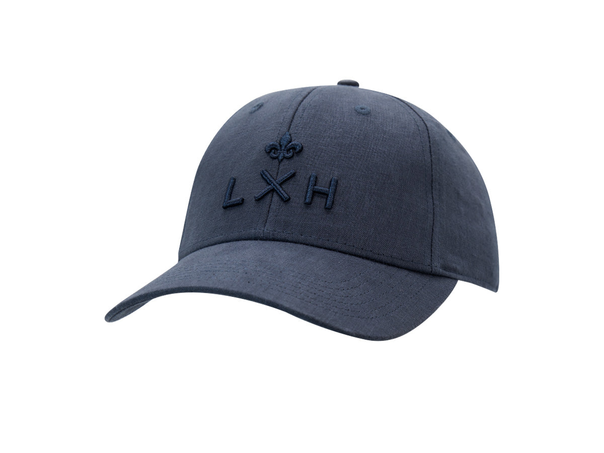 Casquette Héritage LXH en lin bleu abysse, trois quarts avant, monogramme LXH et fleur de lys brodés ton sur ton.